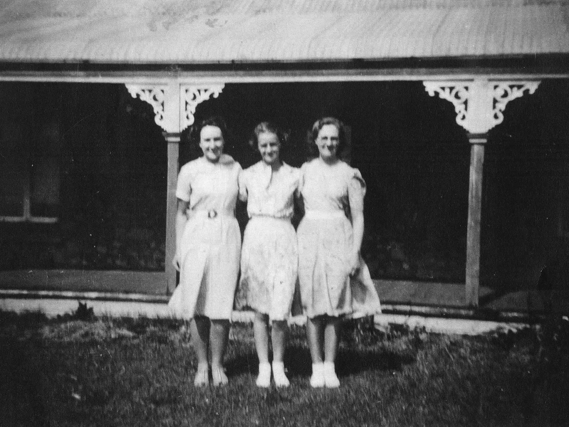 Drei junge Frauen (Meg, Mitte, mit Daphne und Iris) posieren vor dem Pfarrhaus auf einem Foto, das sie die „Drei Blumen“ nannten, 1935